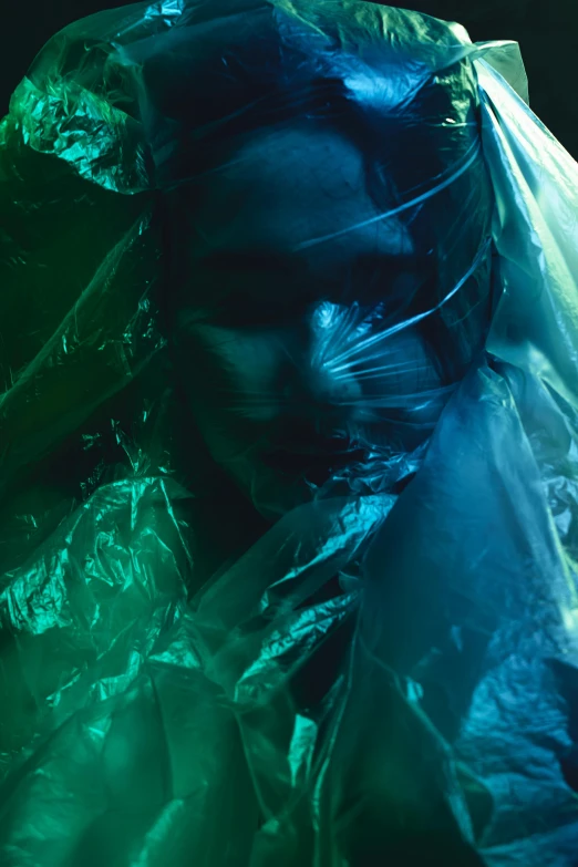 a close up of a person wrapped in plastic, an album cover, inspired by Elsa Bleda, unsplash, plasticien, green cloak, dye contrast lighting, hazmat suits, ((greenish blue tones))