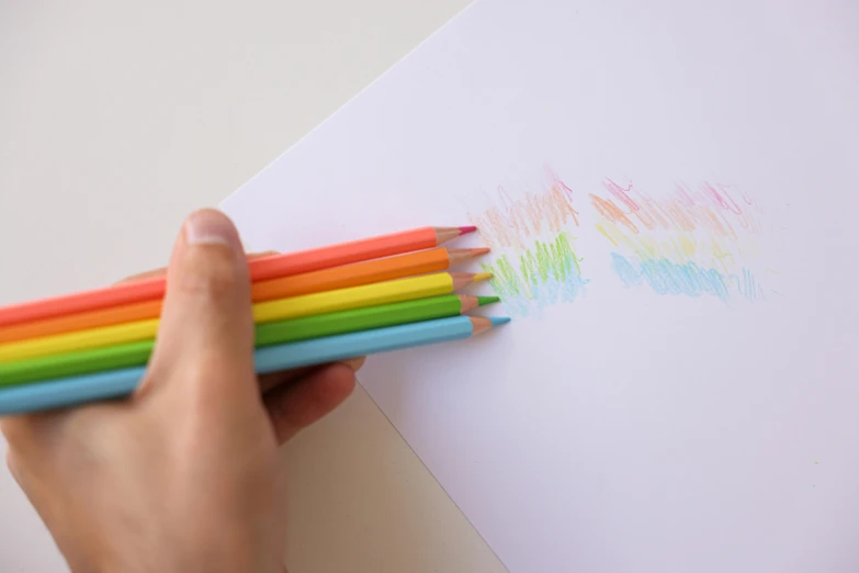 a person holding a bunch of colored pencils, a child's drawing, inspired by Okuda Gensō, drawn on white parchment paper, opening shot, with fluo colored details, using the degrade technique