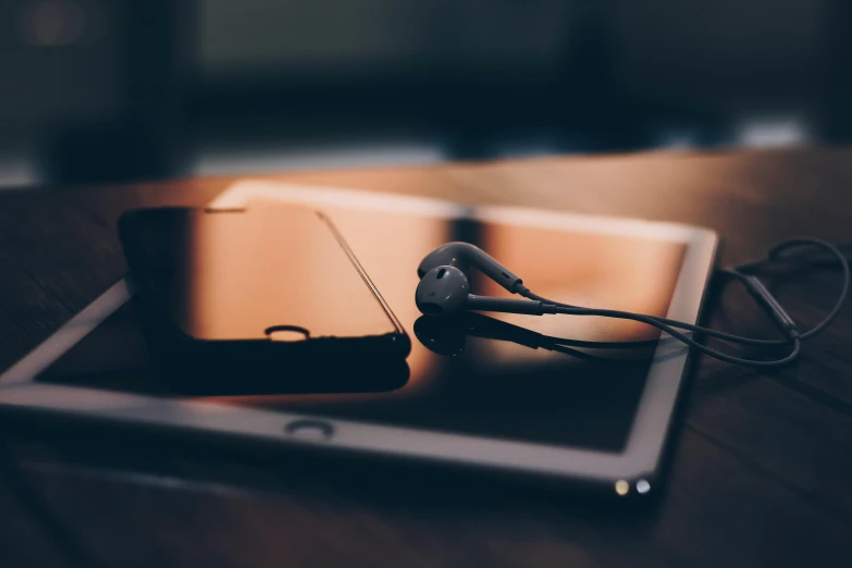 a tablet computer sitting on top of a wooden table, an album cover, trending on pexels, earphones, background image, beautiful iphone wallpaper, intricately defined