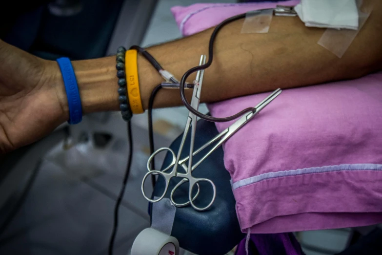 a close up of a person holding a pair of scissors, iv pole, bloodwave, sri lanka, wearing metal gauntlet