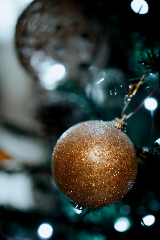 a close up of a christmas ornament on a tree, by David Simpson, pexels, brown and gold, softly - lit, thumbnail, a green