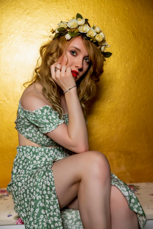 a woman sitting on a bed with a flower crown on her head, a portrait, inspired by Konstantin Somov, reddit, curly blond, pose 4 of 1 6, gold and green, pinup pose