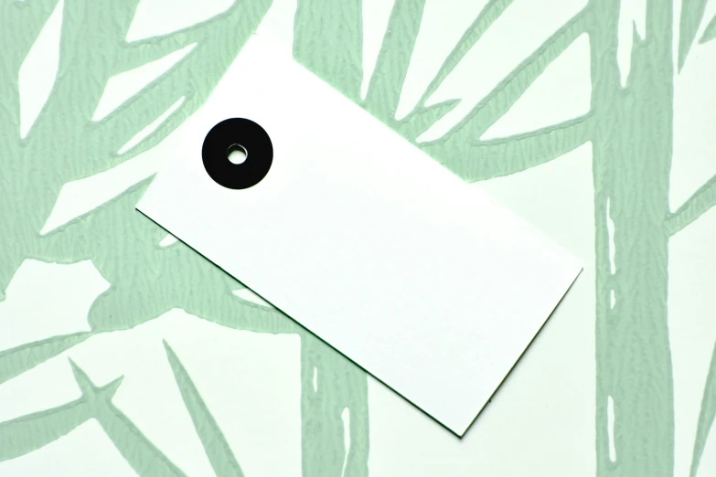 a piece of paper sitting on top of a table, inspired by Maki Haku, unsplash, minimalism, round black eye pupils, tag, diecut, palm