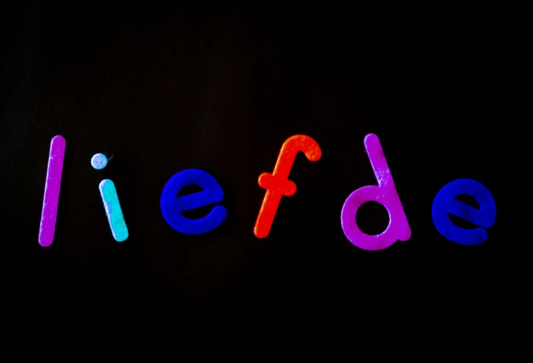 the word liefde is lit up in the dark, an album cover, inspired by Derf, pexels, letterism, children's toy, colorful plastic, helvetica, middle of the day