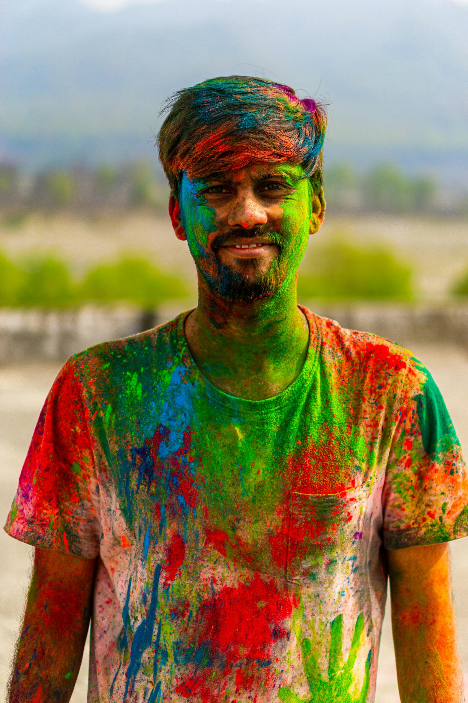 a man with paint all over his face, a colorized photo, pexels contest winner, color field, a portrait of rahul kohli, wearing dirty travelling clothes, colorful]”, multicolor