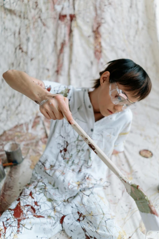 a woman using a paintbrush to paint a wall, a hyperrealistic painting, inspired by Shōzō Shimamoto, trending on unsplash, gutai group, wearing lab coat and glasses, jonathan yeo painting, painting on silk, cai xukun