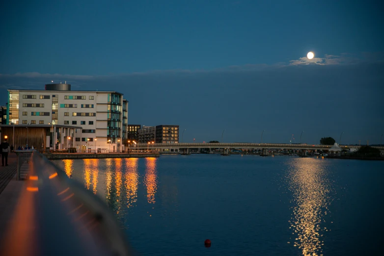 a large body of water with buildings in the background, inspired by Edwin Deakin, pexels contest winner, in front of a big moon, espoo, docks, reykjavik junior college