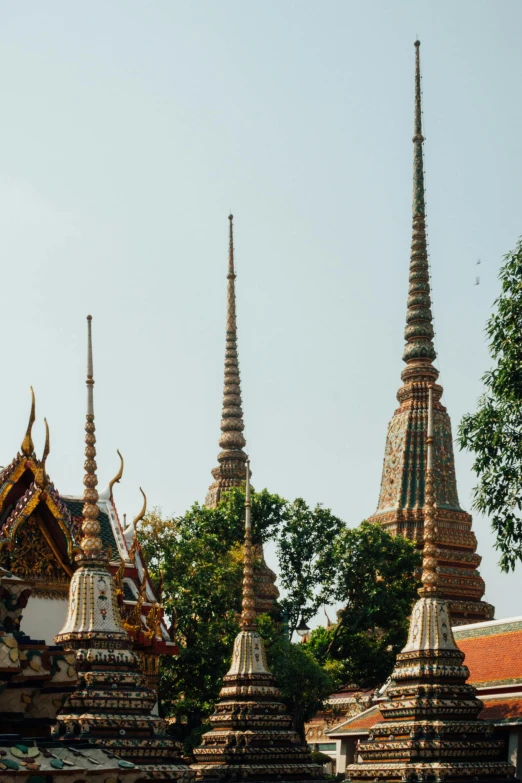 a number of spires on top of a building, bangkok, roofed forest, buzzed hair on temple, high forehead