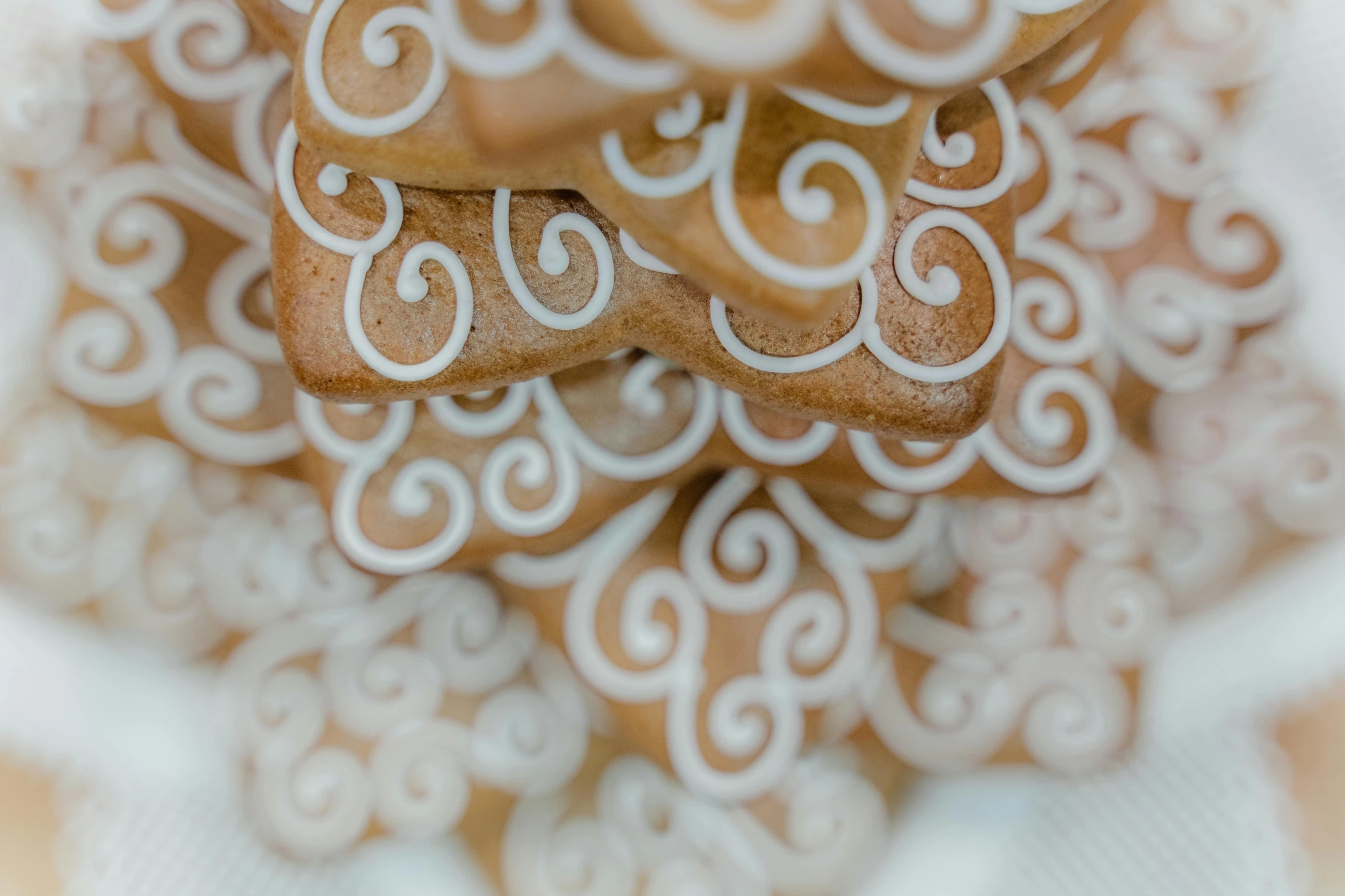 a white plate topped with cookies covered in icing, a stipple, by Emma Andijewska, pexels, renaissance, intricate spirals, holiday, stacked image, made of glazed