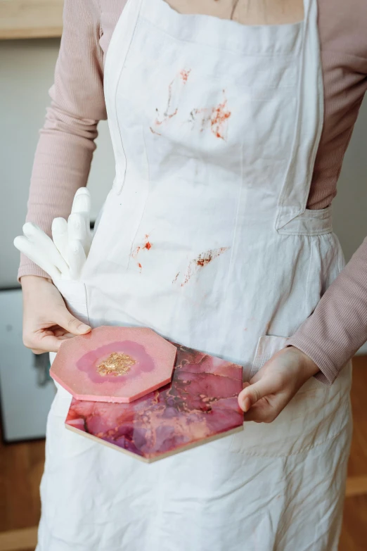 a woman in an apron holding a piece of meat, a marble sculpture, by Julia Pishtar, pexels contest winner, process art, lacquerware, pink and gold color scheme, made of lab tissue, petals