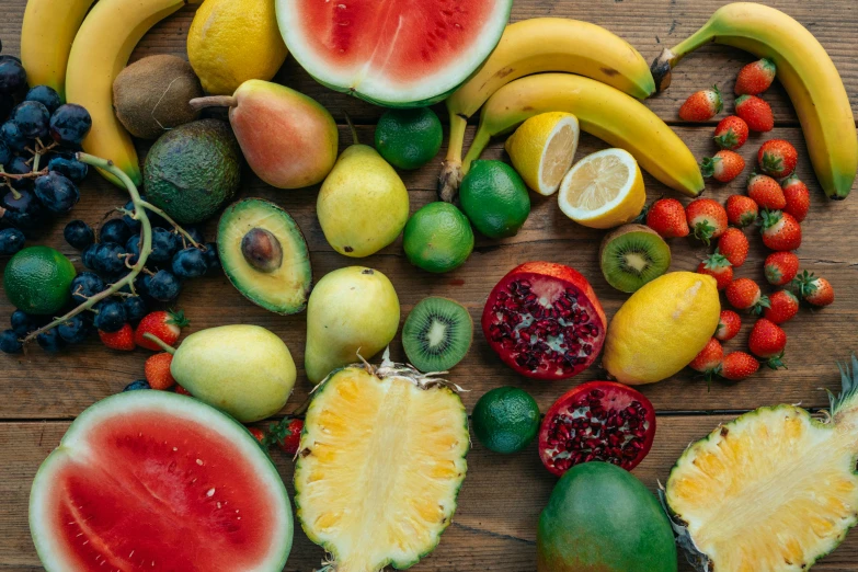 a bunch of fruit sitting on top of a wooden table, brightly coloured, background image