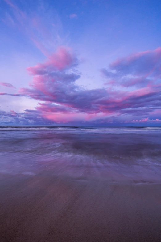 a large body of water next to a sandy beach, by Andrew Geddes, purple omnious sky, australian beach, cotton candy, minn