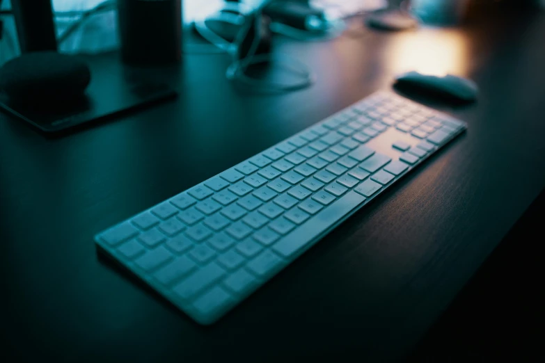 a computer keyboard sitting on top of a wooden desk, by Robbie Trevino, unsplash, it's night time, slide show, modeled, a long-shot