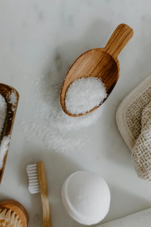 a couple of wooden spoons sitting on top of a counter, soap, close up of single sugar crystal, hair, soft pads