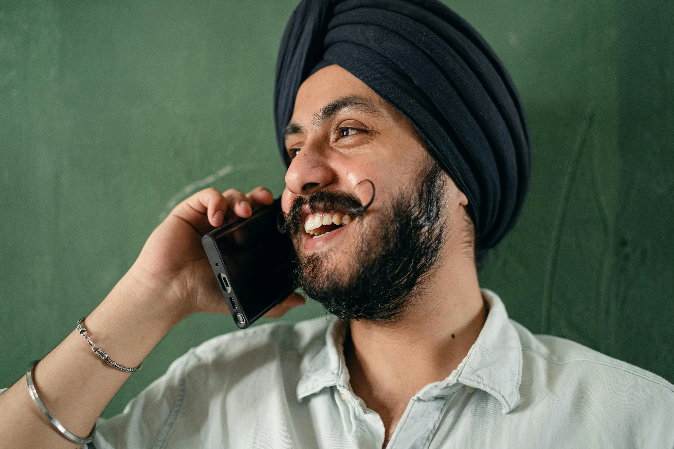 a man in a turban talking on a cell phone, inspired by Manjit Bawa, trending on pexels, in a classroom, thick mustache, friendly smile, promo image