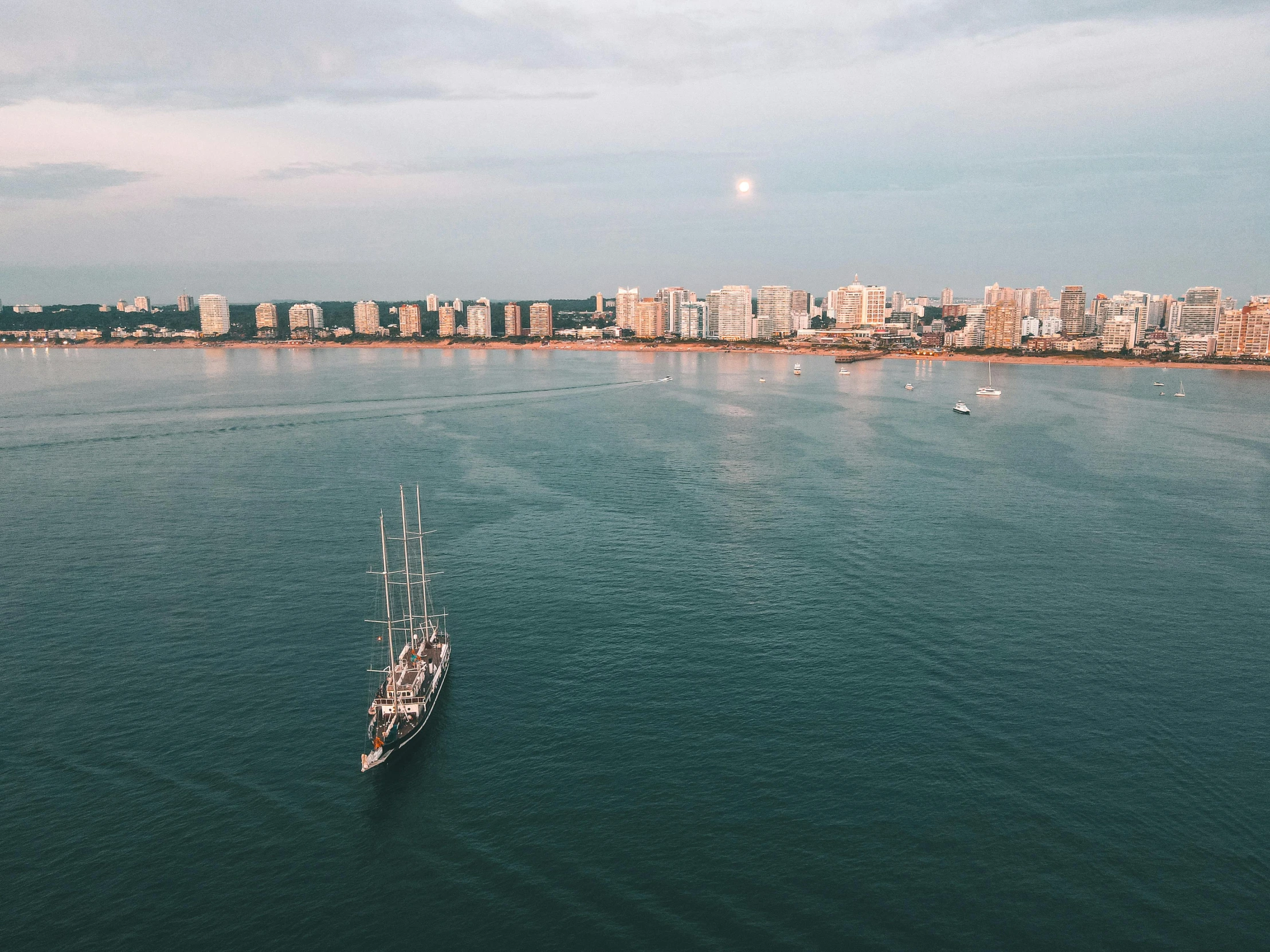 a large body of water with a boat in it, pexels contest winner, vice city, city in the distance, instagram photo, sail