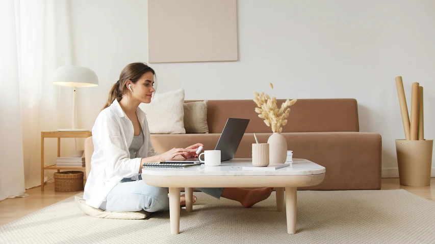 a woman sitting on the floor using a laptop, a computer rendering, inspired by Constantin Hansen, trending on pexels, wooden coffee table, stone table, romanian, calmly conversing 8k