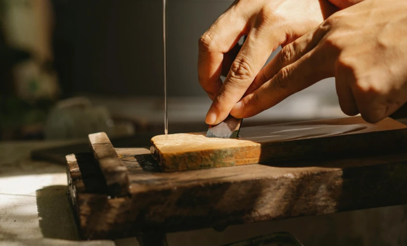 a person cutting a piece of cheese with a knife, inspired by Hasegawa Tōhaku, trending on pexels, arts and crafts movement, wooden jewerly, resin, performing, metalwork