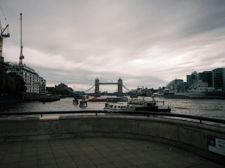 a large body of water with a bridge in the background, inspired by Thomas Struth, pexels contest winner, on a wet london street, overcast gray skies, medium format, grey