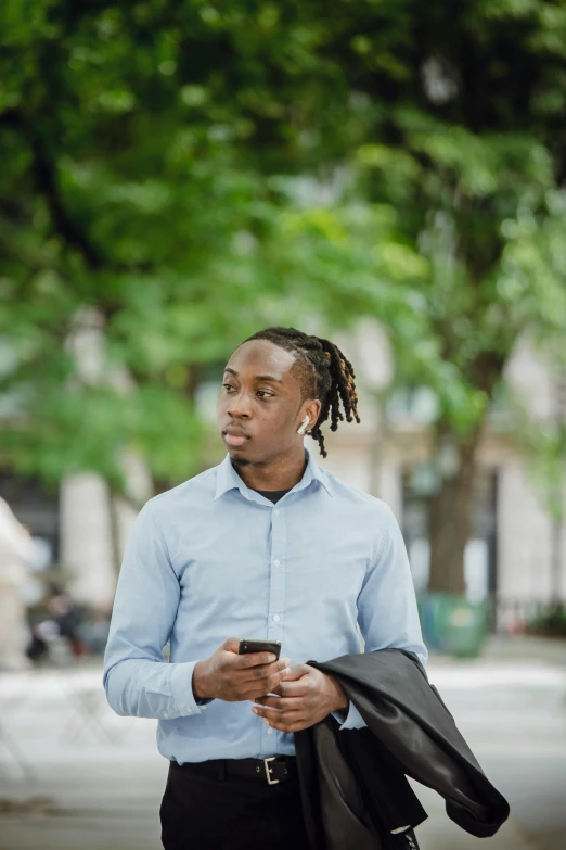 a man with dreadlocks looking at his cell phone, pexels contest winner, walking to the right, androgynous male, wearing a shirt with a tie, pondering