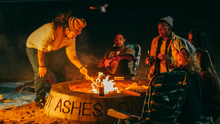 a group of people sitting around a fire pit, by Austin English, tribe members attacking, ashes to ashes, sitting on the beach at night, action sports