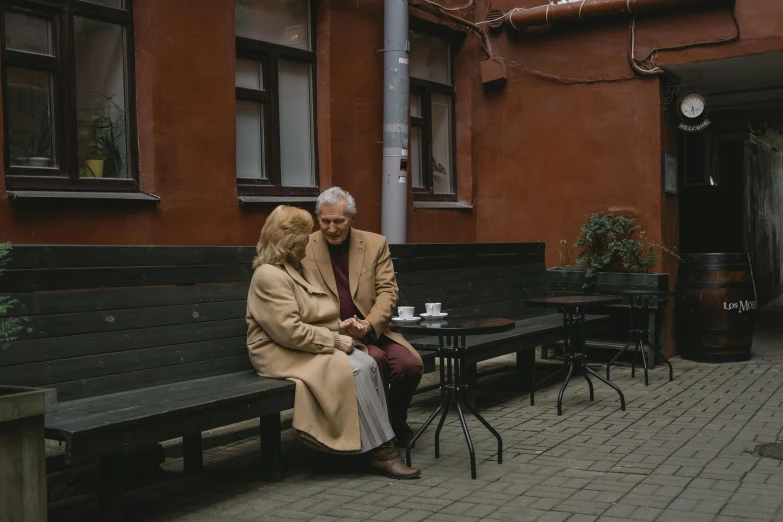 a man and a woman sitting on a bench, a photo, by Attila Meszlenyi, pexels contest winner, brown clothes, elderly, sitting in a cafe, olga buzova