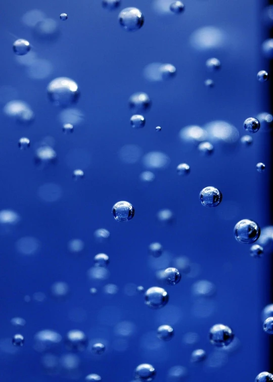 a close up of water bubbles in a glass, an album cover, inspired by Yves Klein, unsplash, conceptual art, blue moon ray tracing, ilustration, space molecules, taken in the late 2010s