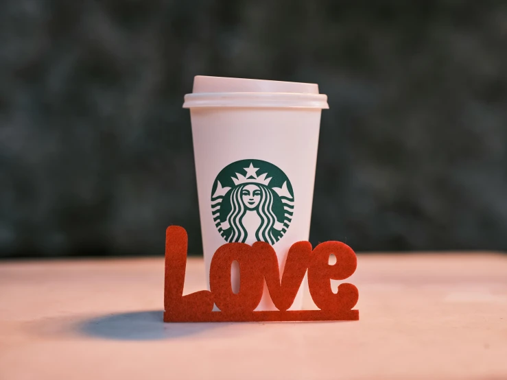 a cup of coffee sitting on top of a table, a 3D render, by Robbie Trevino, trending on unsplash, photorealism, smokey burnt love letters, illustrated starbucks interior, papercraft, they are in love