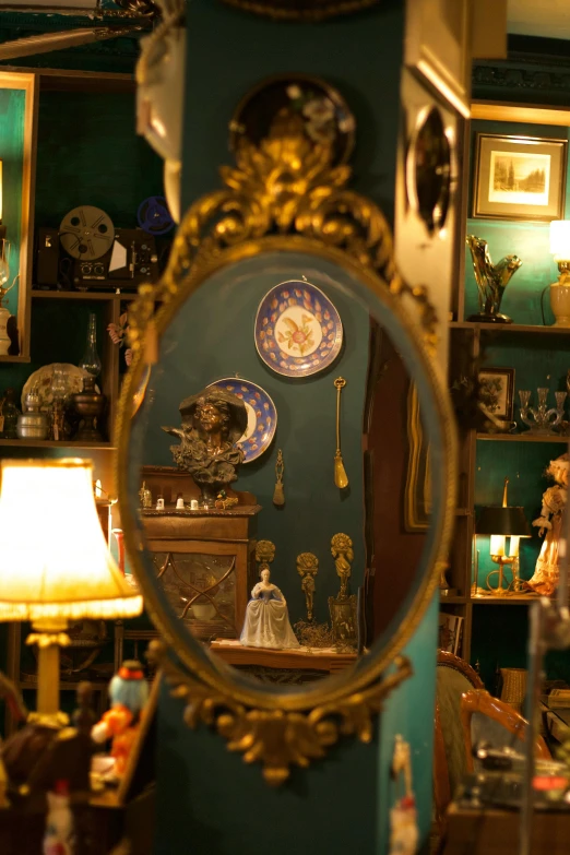 a person standing in front of a mirror in a room, art nouveau, shelves full of medieval goods, blue, antiques, home display