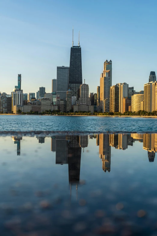a large body of water with a city in the background, by Emanuel Witz, pexels contest winner, chicago, mirrored, panorama, natural morning light