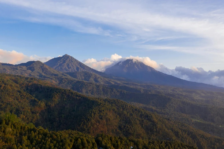 a view of a mountain range with a church in the foreground, unsplash contest winner, sumatraism, infographic of active volcanoes, square, bali, pine forests