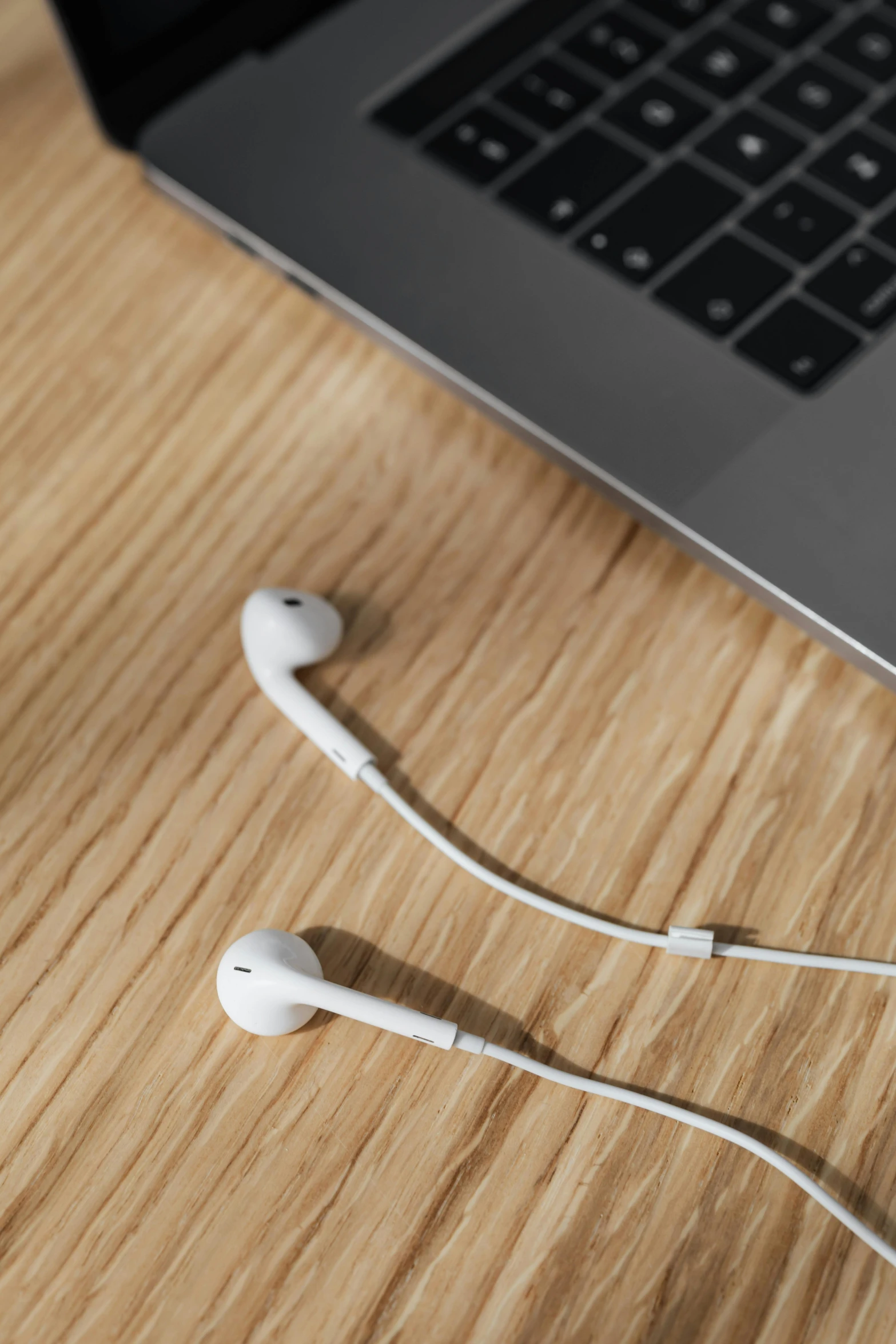 a laptop computer sitting on top of a wooden table, an album cover, by Matthias Stom, unsplash, earbuds, square, closeup, porcelain