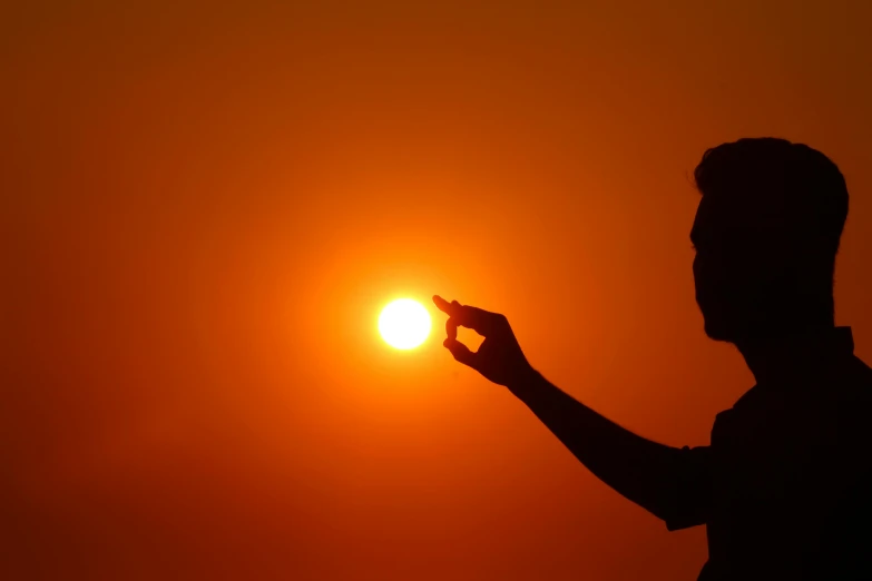 a silhouette of a person holding the sun in their hand, pexels contest winner, orange halo, hot summertime, hd wallpaper, olafur eliasson