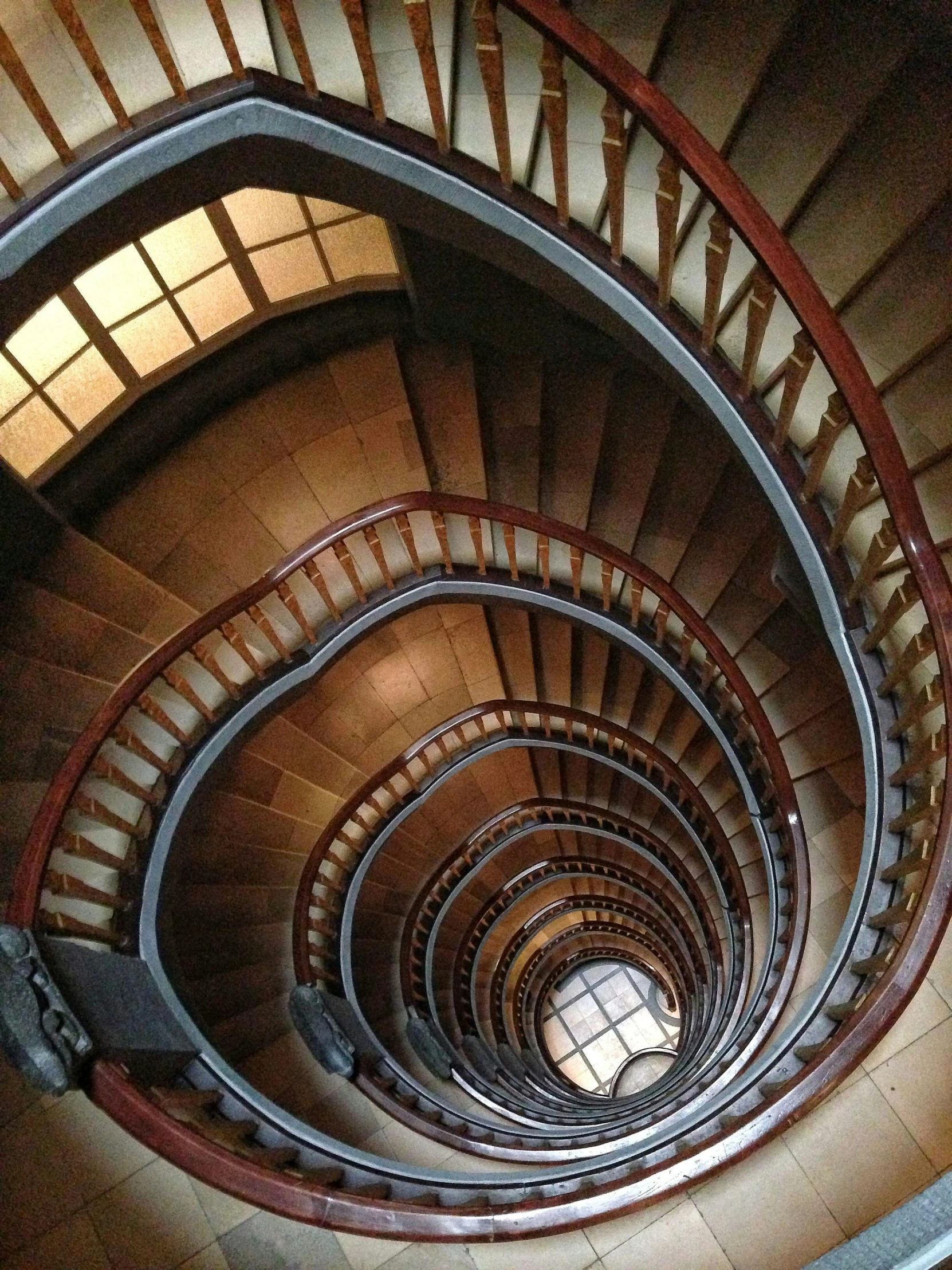 a spiral staircase in a building with a skylight, an album cover, by János Nagy Balogh, pexels contest winner, art nouveau, 2 5 6 x 2 5 6 pixels, staggered depth), brown, in barcelona