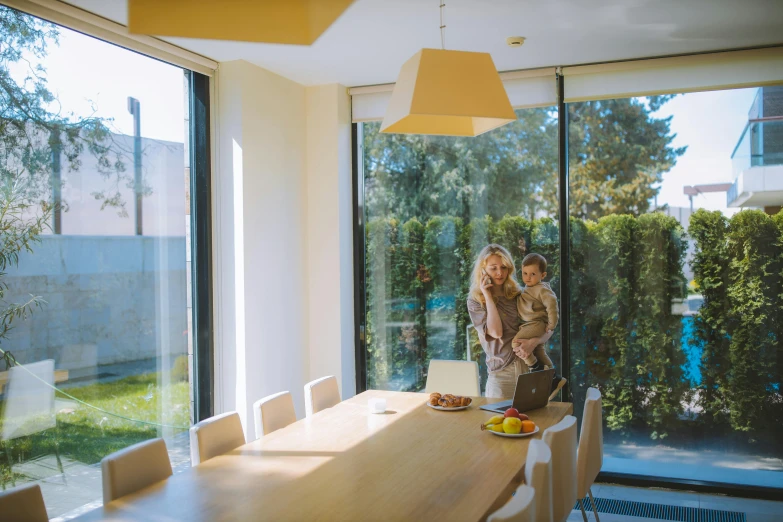 a couple of women standing in front of a table, by Will Ellis, pexels contest winner, light and space, nesting glass doors, families playing, passive house, soft light.4k