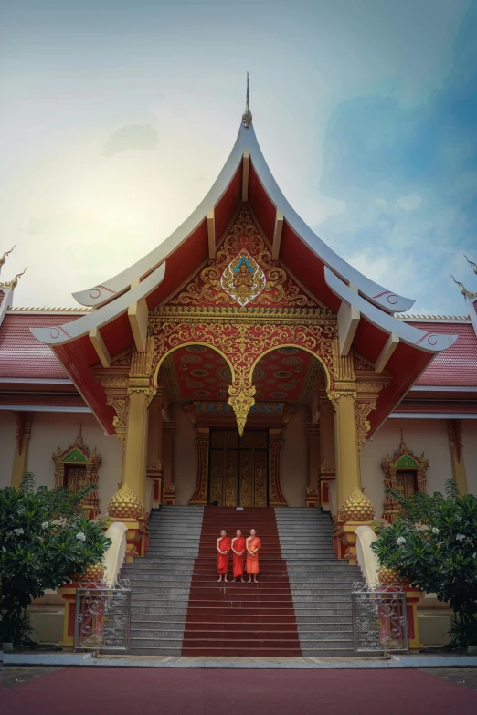 a group of people standing in front of a building, sumatraism, wearing gilded red robes, thai architecture, the narthex, lush surroundings