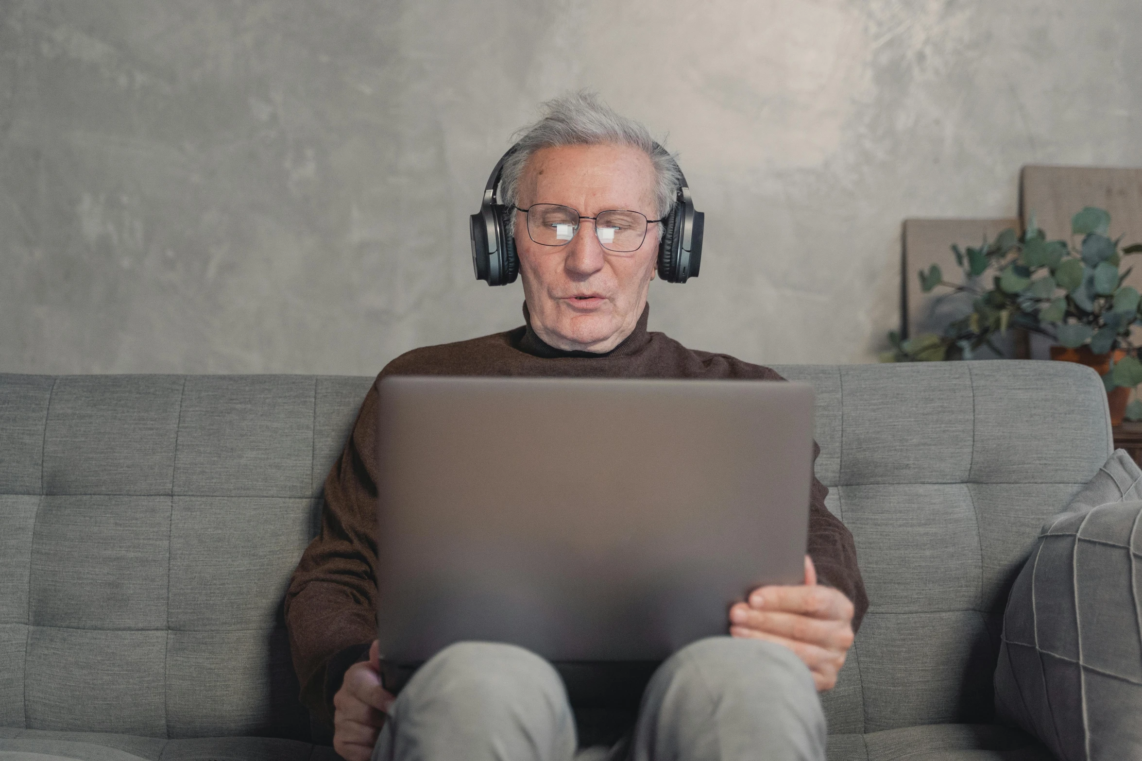 a man sitting on a couch wearing headphones and using a laptop, pexels, computer art, gray haired, brown, mmo, wearing headset