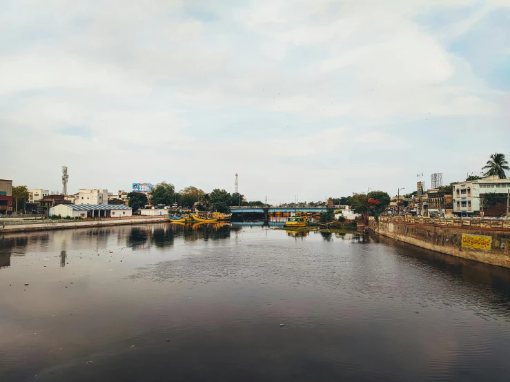 a body of water with a bunch of boats in it, samikshavad, in an urban setting, river running through it, indore, jovana rikalo