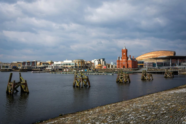 a body of water with a clock tower in the background, by Bedwyr Williams, red castle in background, gigapixel photo, spires, city docks