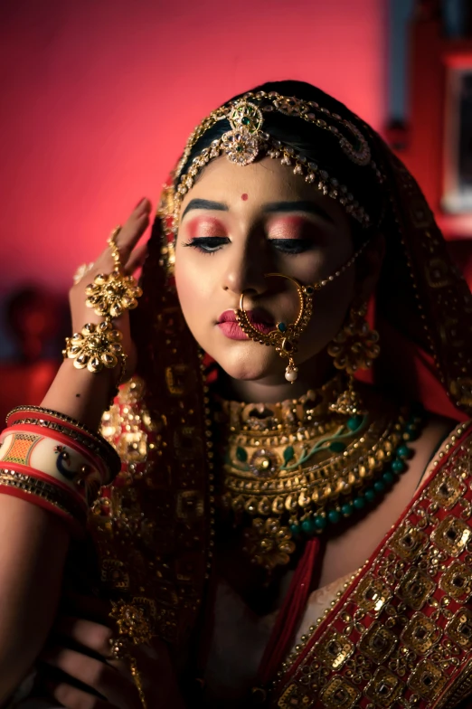 a woman dressed in a red and gold outfit, by Saurabh Jethani, pexels contest winner, with professional makeup, square, [ cinematic, bride