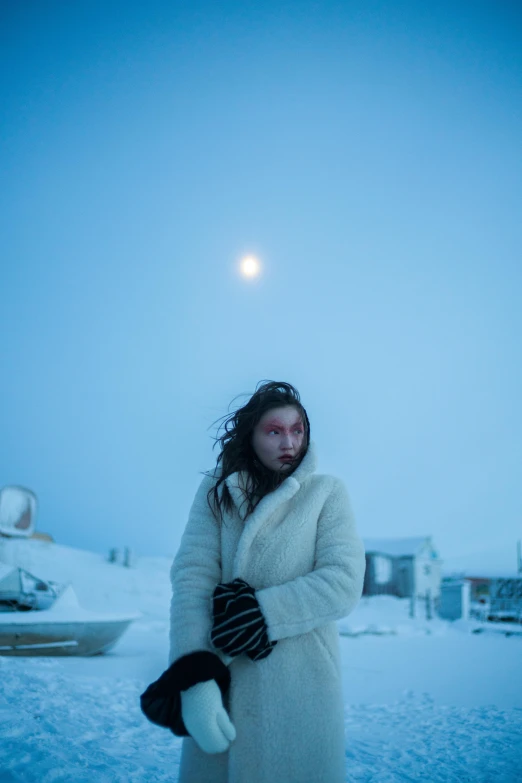 a woman in a white coat standing in the snow, an album cover, by Alasdair Grant Taylor, trending on unsplash, inuit, in front of a full moon, movie set”, world press photo awarded