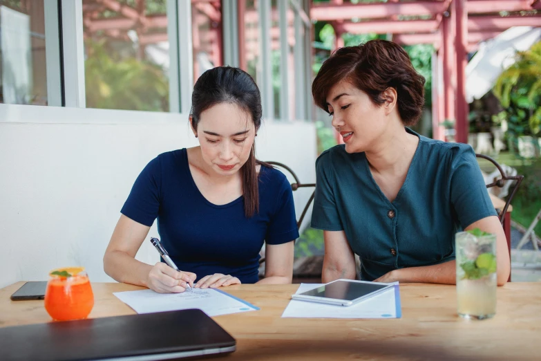 a couple of women that are sitting at a table, pexels contest winner, academic art, background image, writing on a clipboard, asian descent, thumbnail