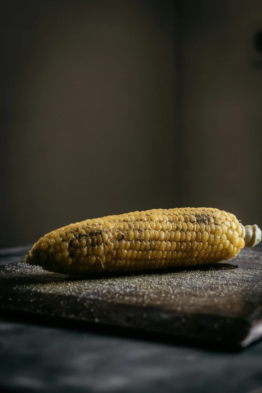 a corn cob sitting on top of a cutting board, a portrait, unsplash, smoked layered, ground - level medium shot, hispanic, made of glazed