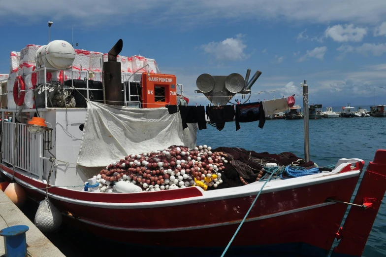 a red and white boat sitting on top of a body of water, hurufiyya, paua shell, fish seafood markets, heavy stacks of pearl necklaces, picard on a starboard