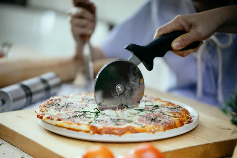 a person cutting a pizza with a pizza cutter, matt finish, mesmerising, bizzaro, family dinner