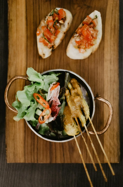 a wooden cutting board topped with a bowl of food, a picture, restaurant, skewer, thumbnail, salad