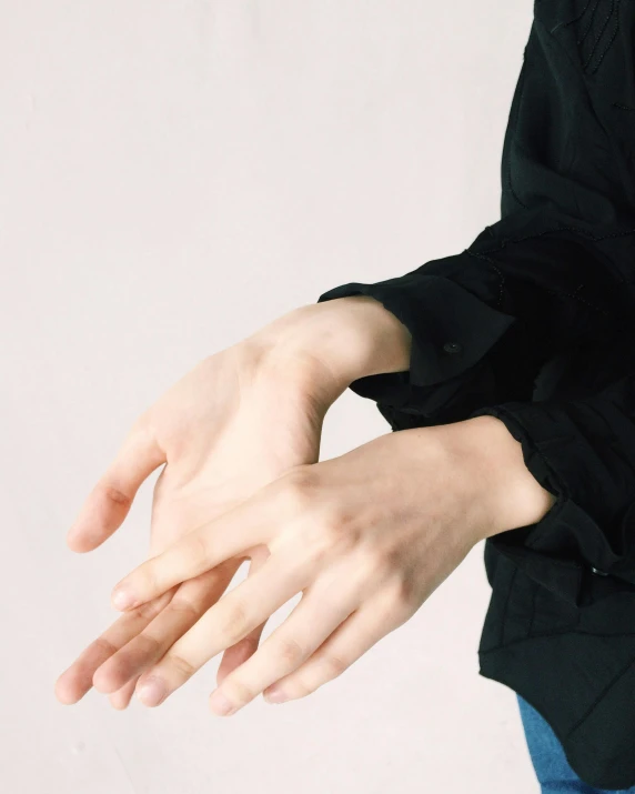 a woman wearing a black shirt and blue jeans, inspired by Vanessa Beecroft, unsplash, glowing hands, non binary model, background image, white sleeves