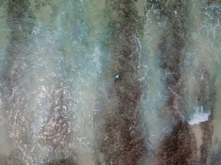 a person riding a surfboard on top of a body of water, inspired by Andreas Gursky, unsplash contest winner, bird's eye, washed colors, blue river in the middle, washed up