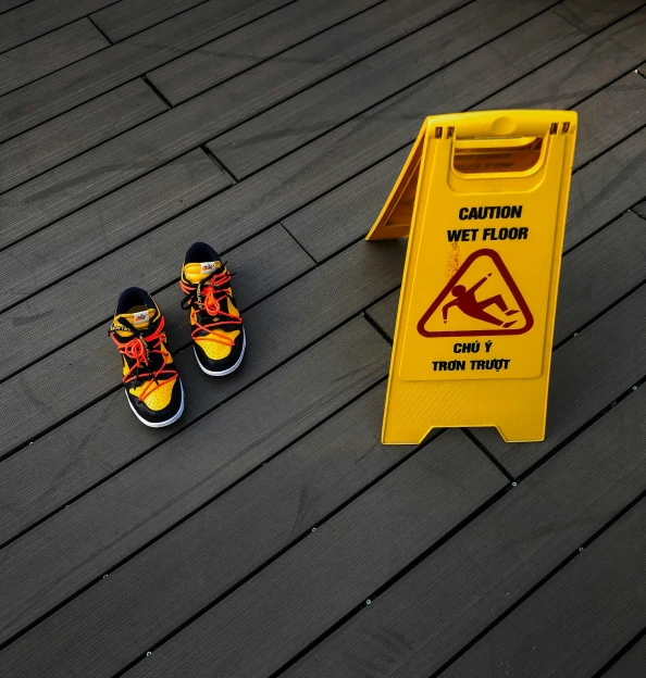 a pair of shoes sitting next to a caution sign, sitting on top a table, walking down, platforms, symbol
