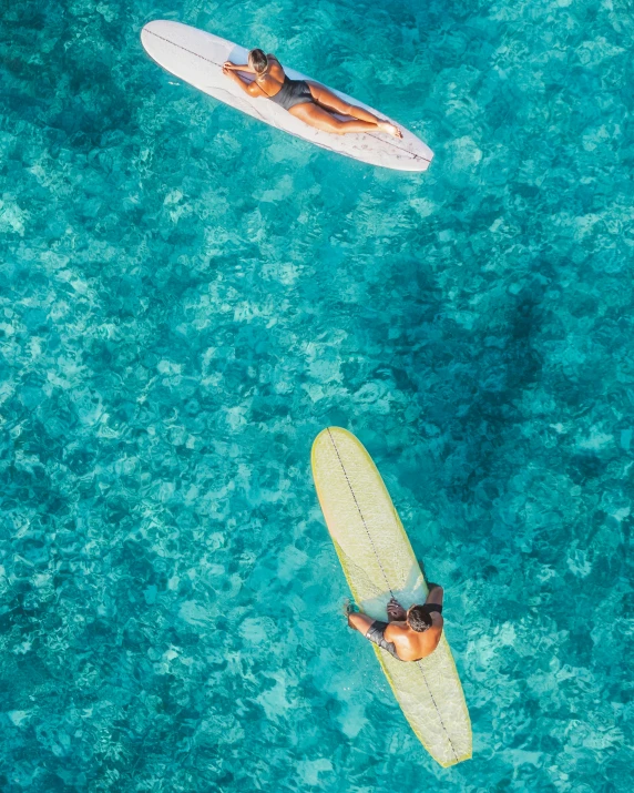 a couple of people riding surfboards on top of a body of water, flatlay, thumbnail, crystal clear blue water, best photo